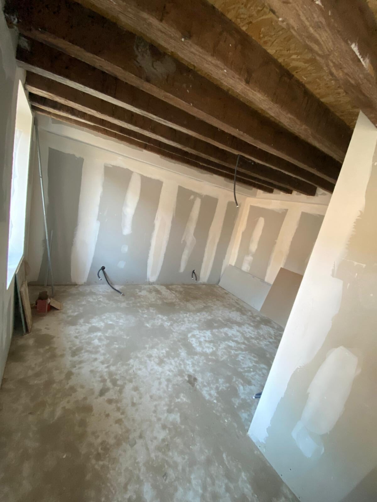 Pièce sous poutres en cours de plâtrerie